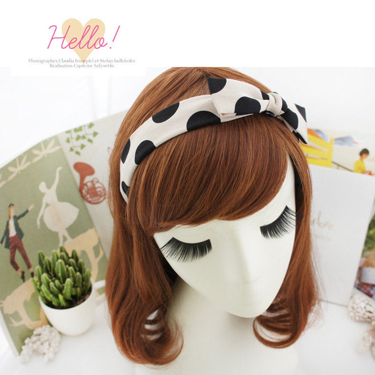 Black polka dots on cream coloured headband with bow