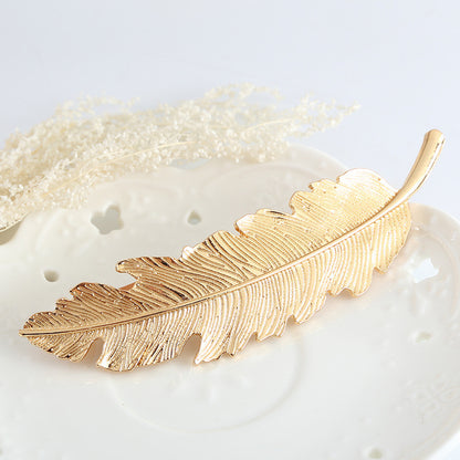 Large metallic feather hair barrette