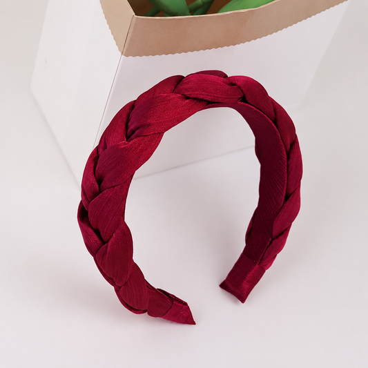 Red braided headband on a white background
