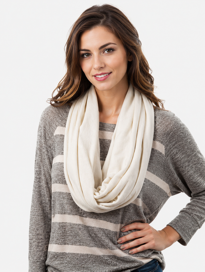 Woman wearing a gray sweater with a white scarf against a white background