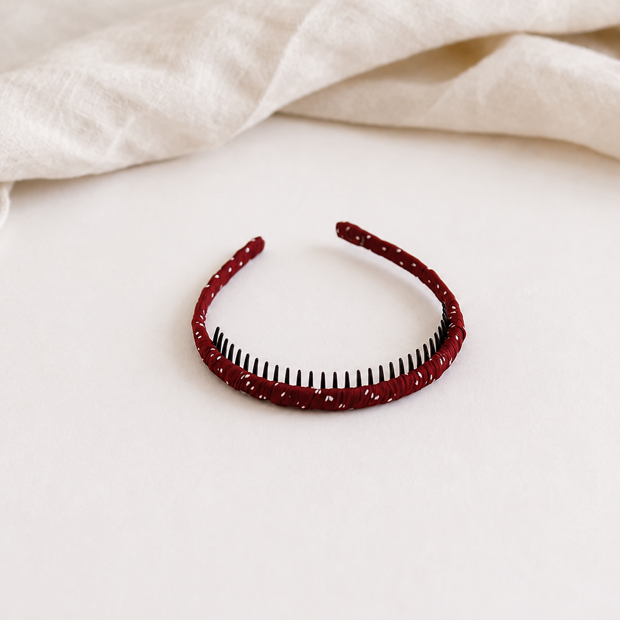 Red headband with black polka dots on a white background