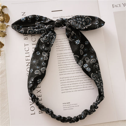 Multi-coloured paisley print elastic headband with bow