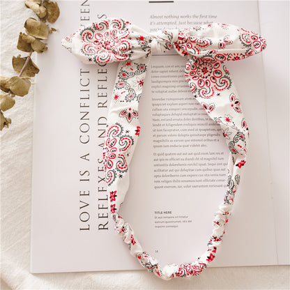 Multi-coloured paisley print elastic headband with bow