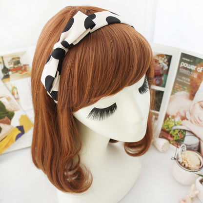 Black polka dots on cream coloured headband with bow